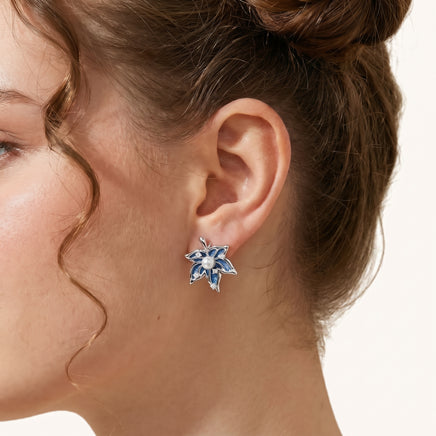 Close-up of blue denim floral stud earring with pearl center, zirconia accents and silver-tone frame | Olaty