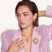 Golden Bow Pearl Blossom Brooch worn on a lilac lapel, featuring a pearl center and sparkling zirconia flower accents | Olaty