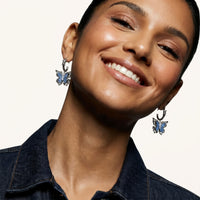 Blue denim butterfly drop earrings worn with sculptural barbed wire inspired hoops and zirconia accents | Olaty