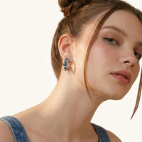 Close-up of blue denim sculptural hoop earrings worn with a denim outfit | Olaty