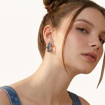 Close-up of blue denim sculptural hoop earrings worn with a denim outfit | Olaty