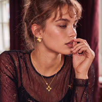 Model styled with Blooming Star open petal gold necklace featuring a brushed floral pendant and sparkling accents | Olaty
