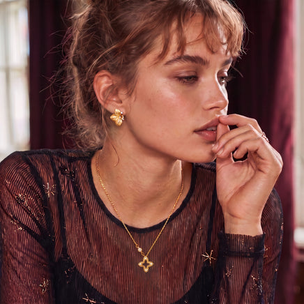 Model styled with Blooming Star open petal gold necklace featuring a brushed floral pendant and sparkling accents | Olaty