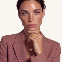 Model wearing sculpted gold initial N pendant necklace with a fine delicate chain | Olaty