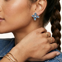 Close-up of blue denim flower stud earring with pearl accents, zirconia details and sculptural silver-tone petals | Olaty