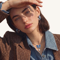 Model wearing blue denim sculpted hoop earrings with polished silver-tone frames | Olaty