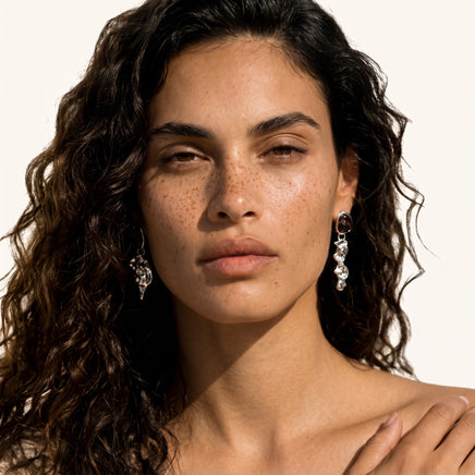 Silver-tone fluid art drop earrings with brown resin tops worn as sculptural statement jewelry | Olaty