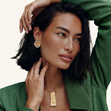 Sculpted rose statement stud earring worn on ear with dimensional gold and silver-tone floral design | Olaty