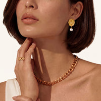 Model wearing a Dragon Phoenix gold stud earring with a white shell pearl drop | Olaty