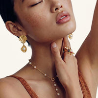 Botanical garden ring with pearl and multicolor stone accents worn with gold shell drop earrings | Olaty