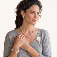 Pearl Cascade Pansy Brooch styled on a grey knit top with white carved flower, pearl cascade and gold-tone chain | Olaty