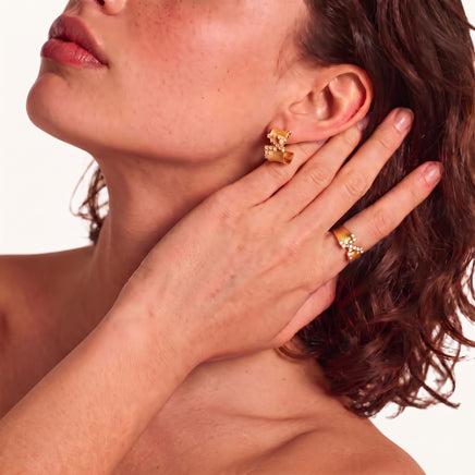 Stardust Scatter Hoop Earrings worn on ear, showcasing the sculptural brushed-gold hoop design with cubic zirconia clusters | Olaty