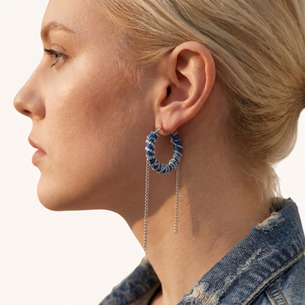 Close-up of Denim Dream hoop earring styled with denim, showing blue fabric texture and dangling silver-tone chains | Olaty