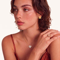 Model wearing braided clover halo stud earring with textured gold center and cubic zirconia border | Olaty
