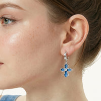 Close-up of blue denim cross drop earring with zirconia-set hoop and textured metal frame | Olaty