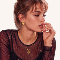 Model wearing Bloom sculpted gold petal stud earrings with delicate cubic zirconia accents | Olaty