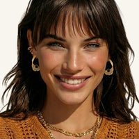 Sculptural gold mesh earrings with black resin center accents worn for a bold statement look | Olaty