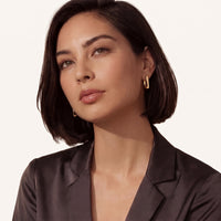 Model wearing Golden Hour Sculpted Huggie Earrings with sleek geometric gold profiles and minimalist styling | Olaty