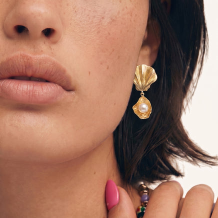 Close-up model view wearing gold scallop shell drop earring with luminous freshwater pearl | Olaty