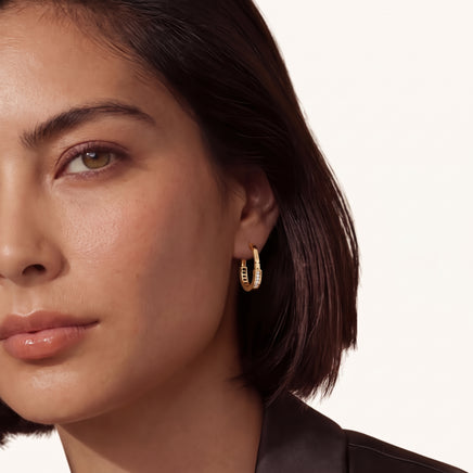 6. Model wearing geometric gold huggie hoop earrings with Cubic Zirconia | Olaty