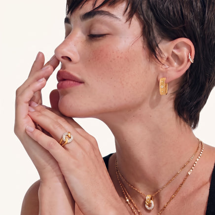 Side profile of model wearing sculptural baroque gold huggie hoop earrings | Olaty