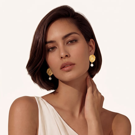 Model wearing Dragon Phoenix gold pearl drop earrings with sculptural medallion design | Olaty