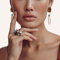 Front view of amber baroque pearl drop earrings worn with turquoise accents and gold chain details | Olaty