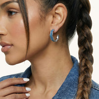 Close-up of blue denim hoop earring showing curved fabric inlay and sculpted silver-tone frame | Olaty