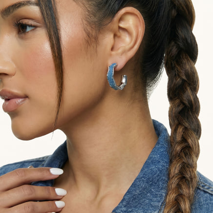 Close-up of blue denim hoop earring showing curved fabric inlay and sculpted silver-tone frame | Olaty
