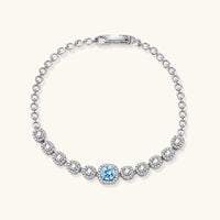 Front view of Azure Tennis Bracelet with blue round moissanite centerpiece, halo settings and polished sterling silver links | Olaty