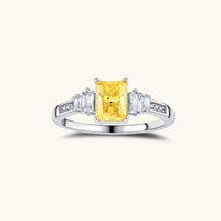 Yellow moissanite three stone ring front view with radiant cut center and clear side stones | Olaty