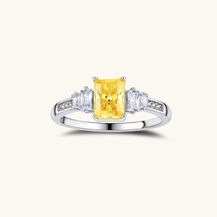 Yellow moissanite three stone ring front view with radiant cut center and clear side stones | Olaty