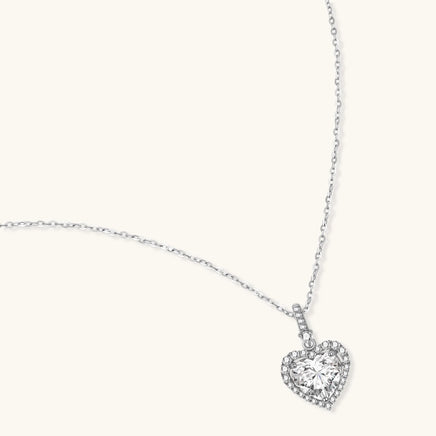 Angled view of heart cut moissanite halo pendant necklace in polished 925 sterling silver | Olaty