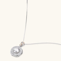 Angled view of round moissanite halo pendant with geometric baguette details and sterling silver chain | Olaty