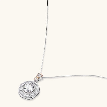 Angled view of round moissanite halo pendant with geometric baguette details and sterling silver chain | Olaty