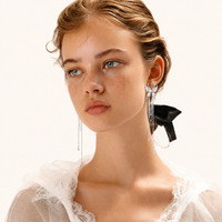 Celestial Phoenix pearl cascade statement earrings with wing design and long chains styled on model | Olaty