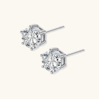Angled view of round moissanite stud earrings with six-prong sterling silver settings and posts | Olaty