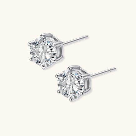 Angled view of round moissanite stud earrings with six-prong sterling silver settings and posts | Olaty