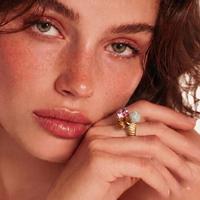 Close-up of model wearing sculptural statement ring with pink, amber and pavé crystal elements | Olaty