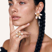 Model wearing oversized white enamel lily statement ring with matching floral earring | Olaty