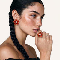 Model wearing crimson floral statement ring with matching red flower earrings | Olaty