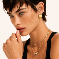 Model wearing Liquid Gold Sculptural Hoops with layered gold jewelry | Olaty