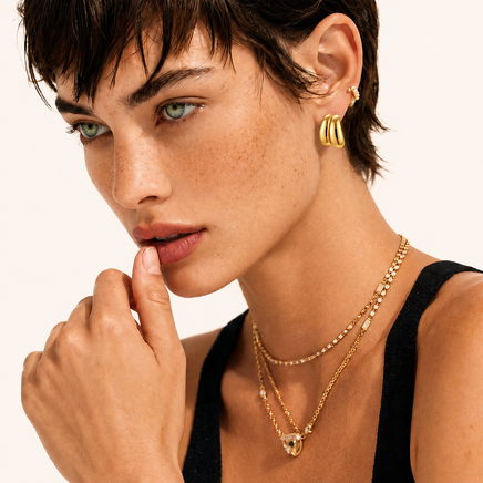 Model wearing Liquid Gold Sculptural Hoops with layered gold jewelry | Olaty