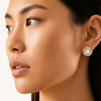 Gold sunburst pearl stud earring with radiating crystal halo worn on model close-up | Olaty