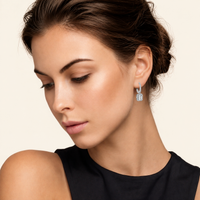 GRA certified moissanite drop earring worn on ear with emerald cut stone and polished silver setting | Olaty