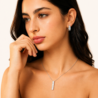 Model wearing baguette zirconia huggie earrings and linear pendant necklace | Olaty