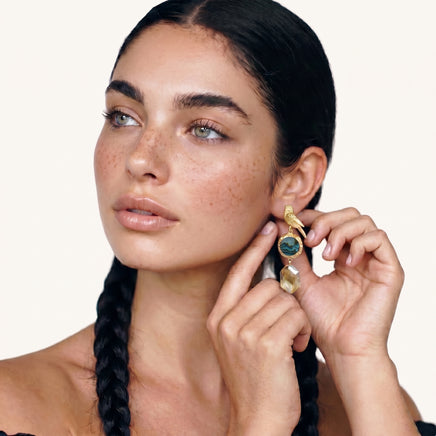 Model wearing long gold songbird earring with iridescent abalone shell and champagne crystal drop | Olaty