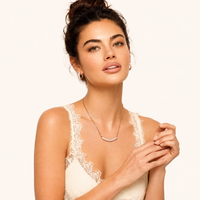 Model wearing rose pavé zirconia curved bar necklace and huggie hoop earrings | Olaty