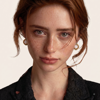 Model wearing Mother of Pearl and green Zirconia round stud earrings with ornate gold-tone frames | Olaty