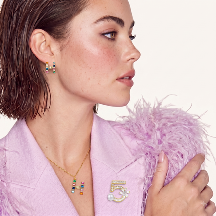 Model wearing rainbow zirconia H initial pendant necklace and matching stud earrings | Olaty